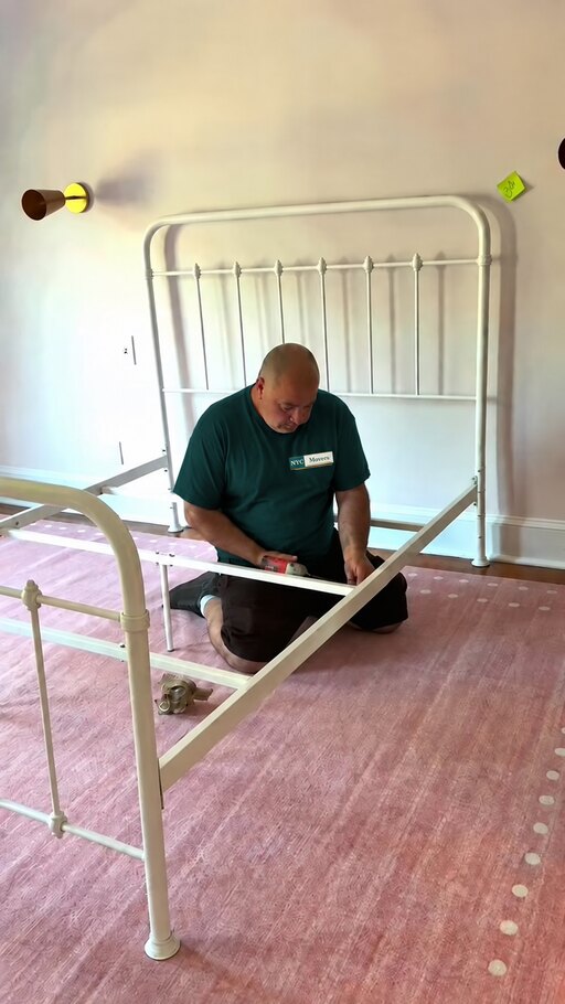 Professional mover reassembling a bed frame after a move
